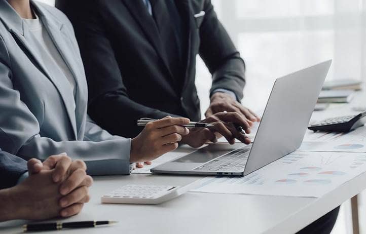 Business professionals typing on their laptop.