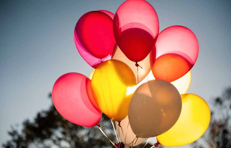 Red and yellow balloons in front of the sun