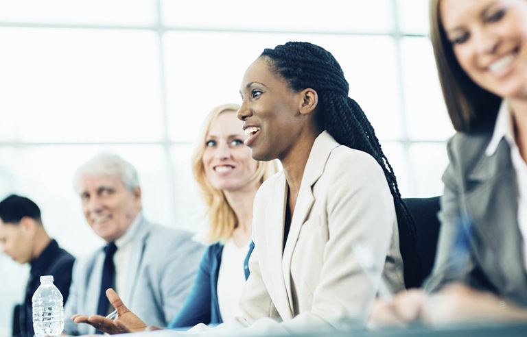 Group of business professionals smiling and talking.