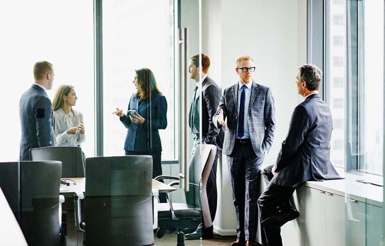 Group of business professionals talking in a conference room.