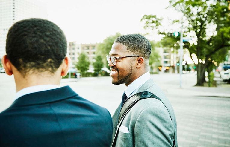 Two business professionals smiling and walking to work.