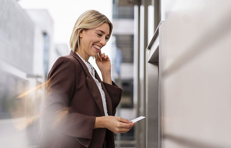 Business professional walking outside and looking at their cell phone.