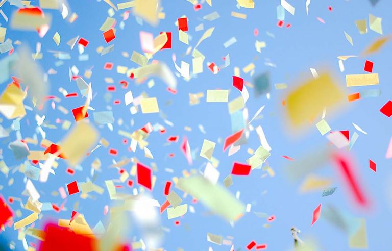 Colorful confetti against a blue sky.