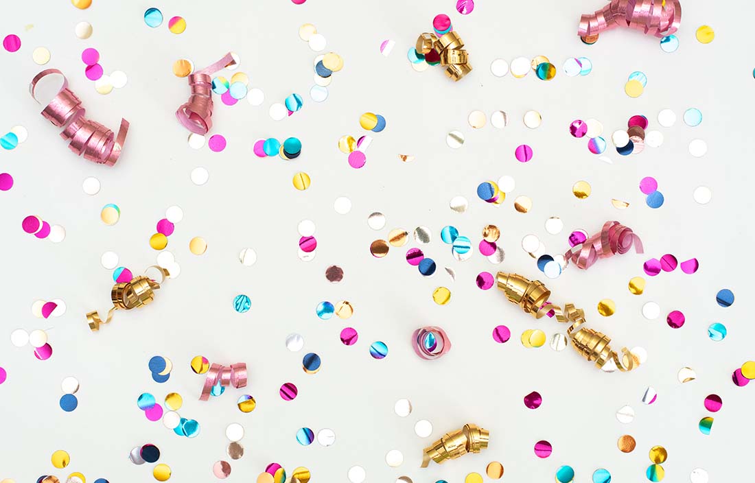 Colorful confetti against a white background.