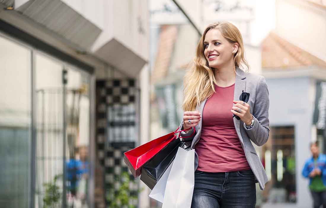 Customer with their shopping bags walking around a mall.