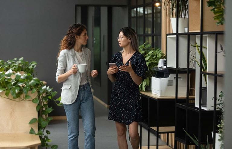 Two healthcare professionals walking down a hallway and discussing today's healthcare landscape.