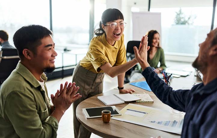 Group of coworkers high-fiving.