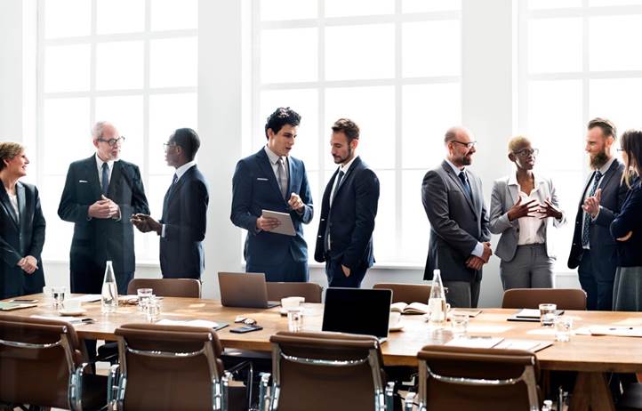 Group of business professionals talking in a board room.