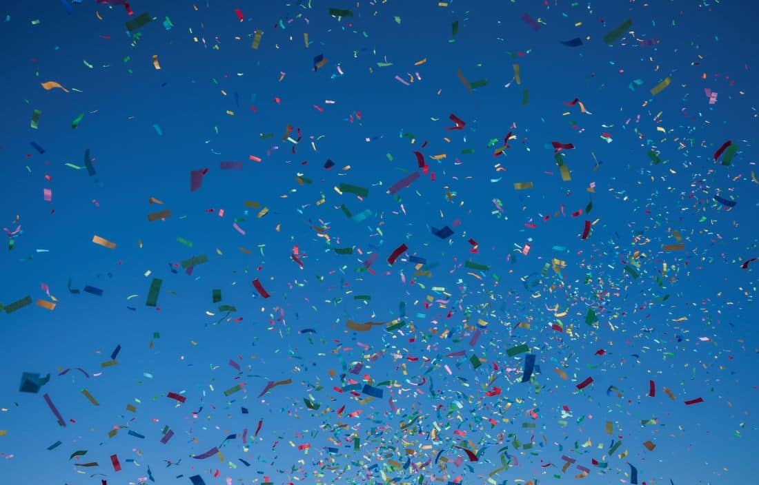 Colorful confetti on a dark blue background.
