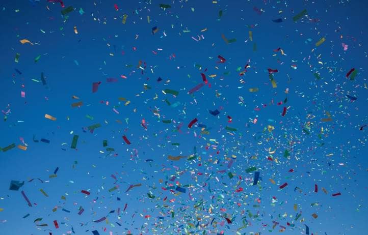 Colorful confetti on a dark blue background.