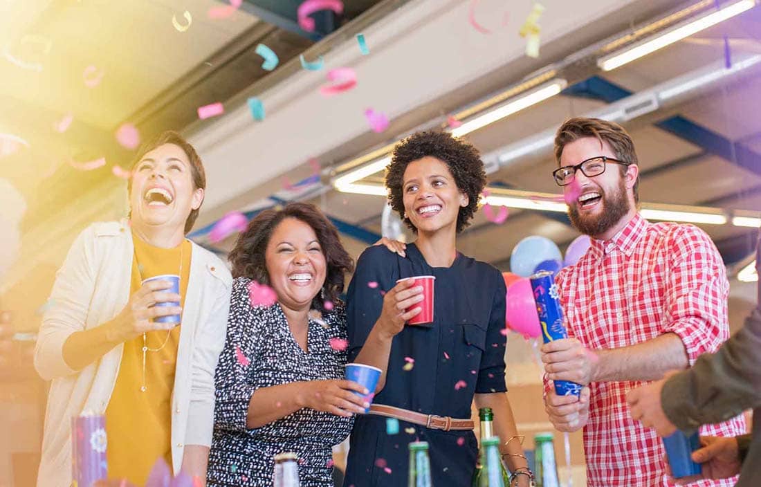 Business professionals celebrating with confetti at work.