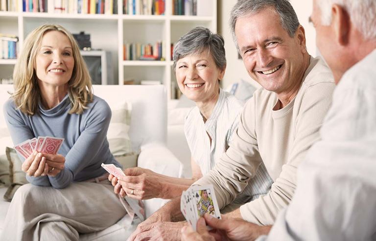 Adults 55 and older enjoying a card game at an active adult community