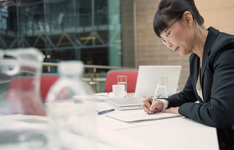 Image of a business woman writing in a notebook