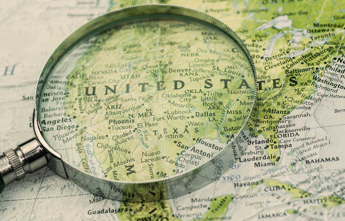 Close-up image of a United States map with a magnifying glass laying over most f the continental USA