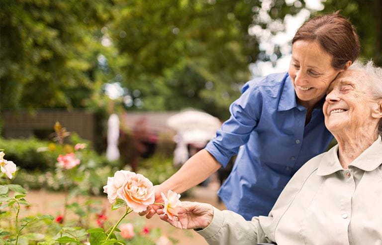 Image of two women looking at a rose bush