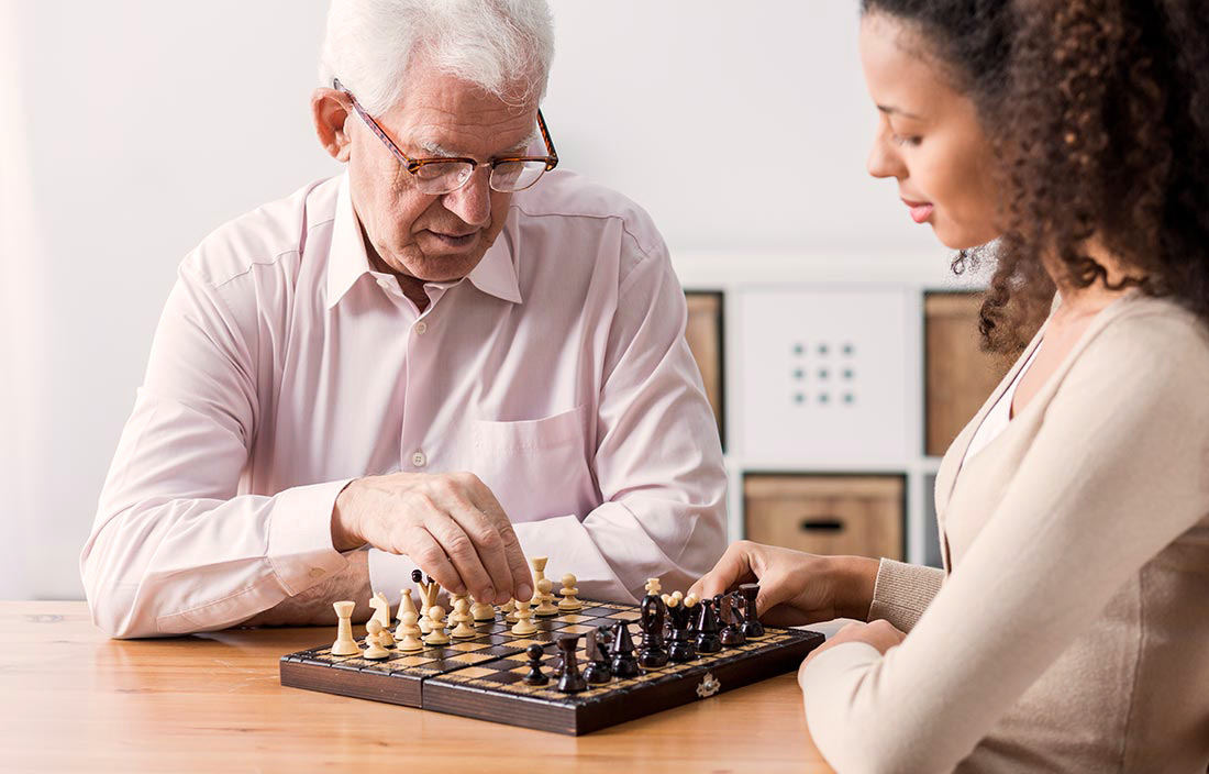 Older man and younger woman playing chess