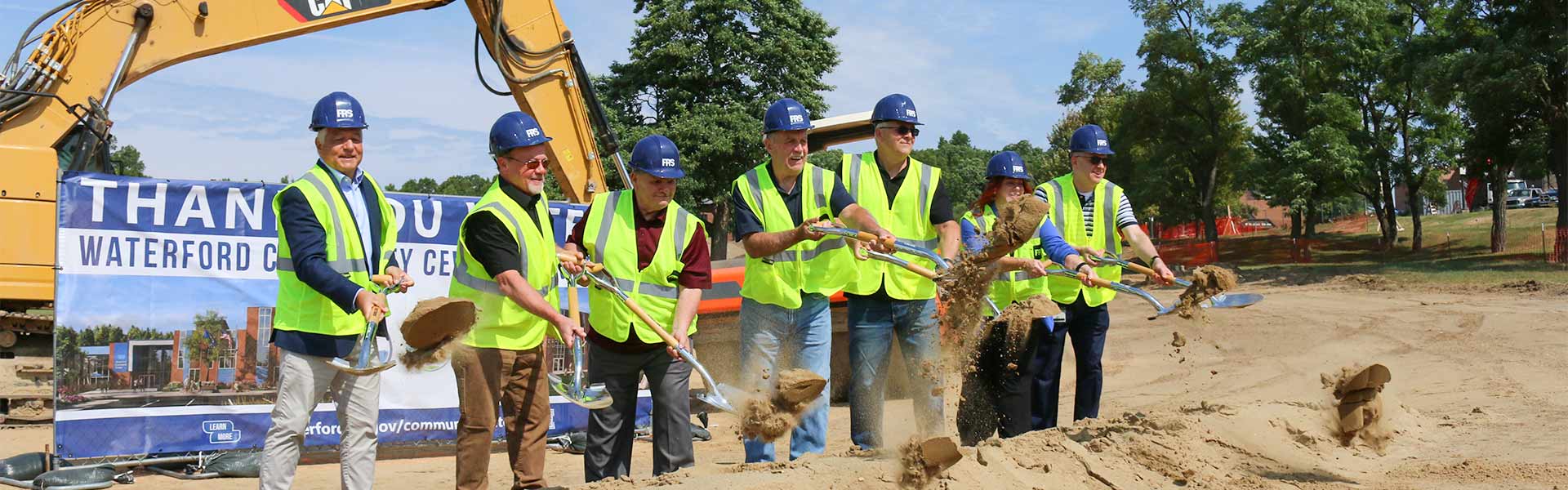 Construction workers digging at the Waterford Township community center groundbreaking ceremony.