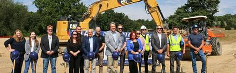 People smiling at the Waterford Township community center groundbreaking ceremony.