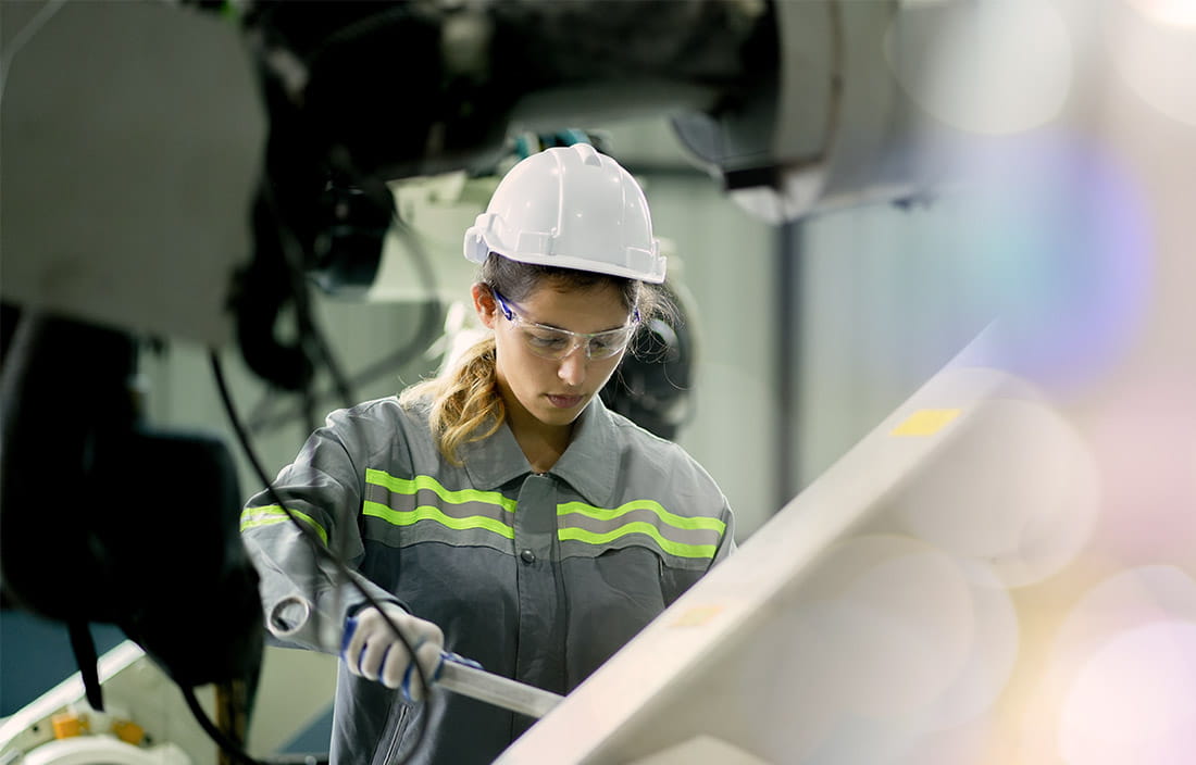 Woman in a manufacturing plant, as seen through some equipment