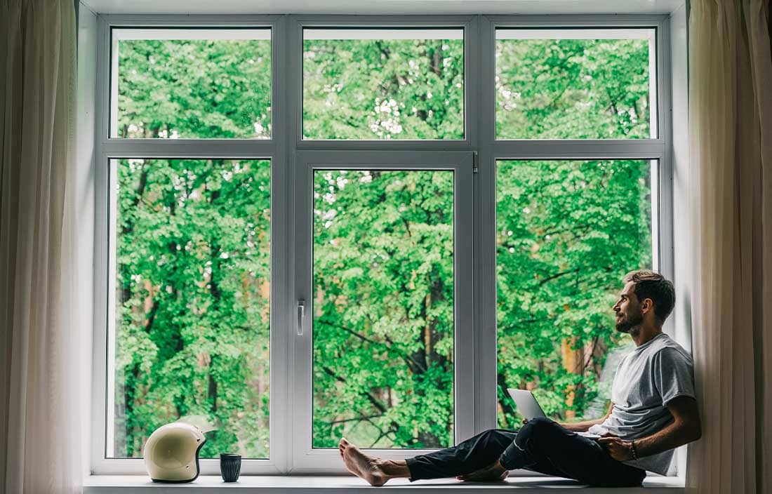 Man sitting in window looking outside.