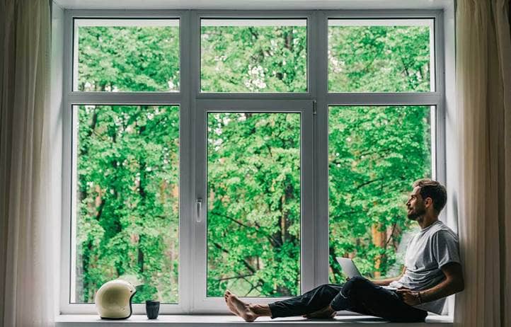 Man sitting in window looking outside.