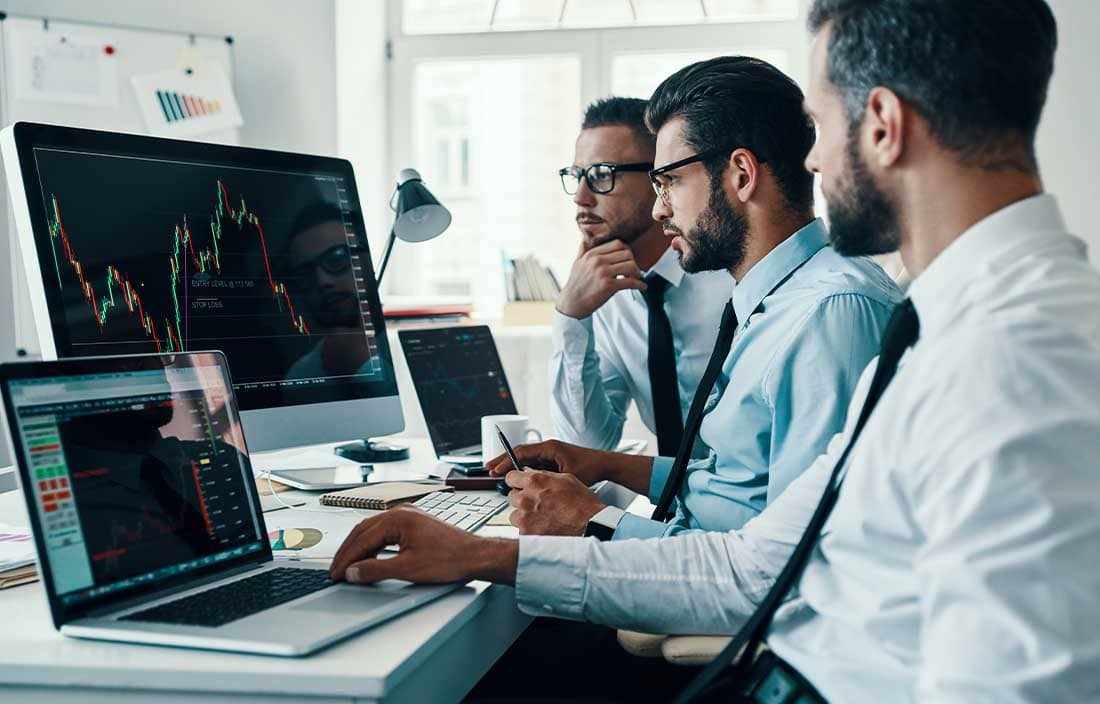 Three men looking at computer screens.