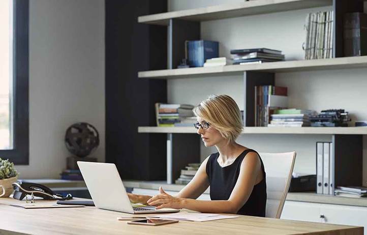 Business professional sitting in an office using a high-end laptop.